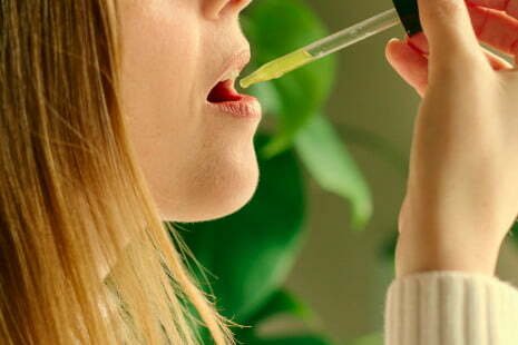 femme qui ingère de l'huile de cbd bio