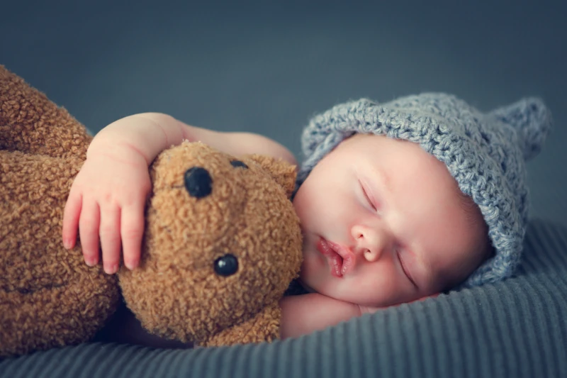 bébé qui dort avec un ours en peluche